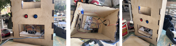 Finished autonomous zoo exhibit habitat, showing the front control panel with buttons and the wired interior with Arduino and trapdoor mechanism